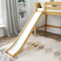 Wooden loft bed with slide in a modern neutral kids' bedroom, natural wood finish, gray curtains, boho rug, built-in shelves