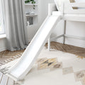 White kids loft bed with slide in modern neutral nursery, gray curtains, built-in shelves with plant and alarm clock on herringbone wood floor