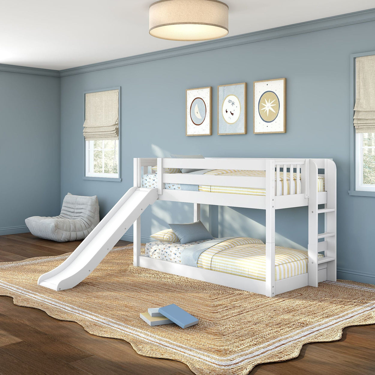 White twin-over-twin bunk bed with slide in children's bedroom with soft blue walls, wooden ladder, natural jute rug, framed art and windows