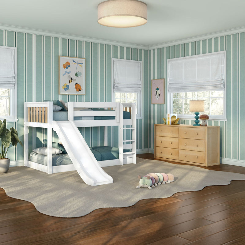 Kids bunk bed with slide in teal-striped bedroom, white frame, wooden dresser, plush rug, lamp and toy caterpillar