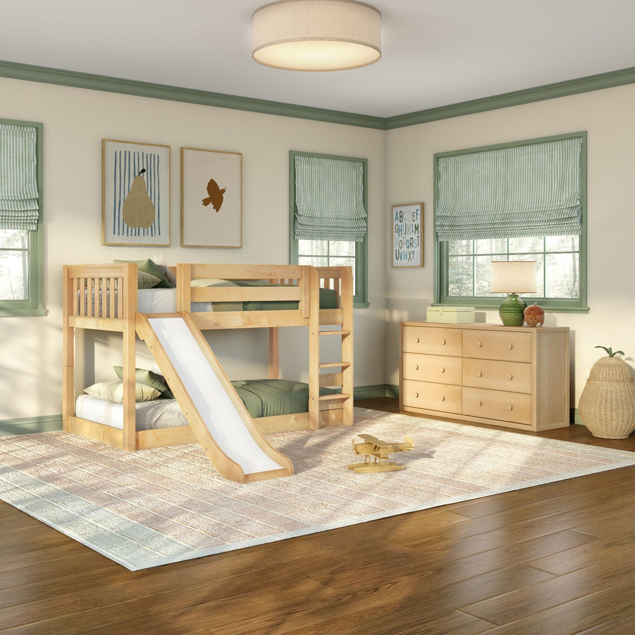 Bright kids bedroom featuring a natural wood bunk bed with slide, green-trim windows, matching dresser, wall art, area rug and hardwood floors