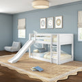 White wooden bunk bed with slide in light-blue kids' bedroom with striped bedding, framed wall art, beige woven rug and natural light