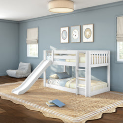 White wooden twin-over-twin bunk bed with slide and ladder in a light blue kids' bedroom with striped bedding, jute rug, wall art, and a cozy beanbag chair