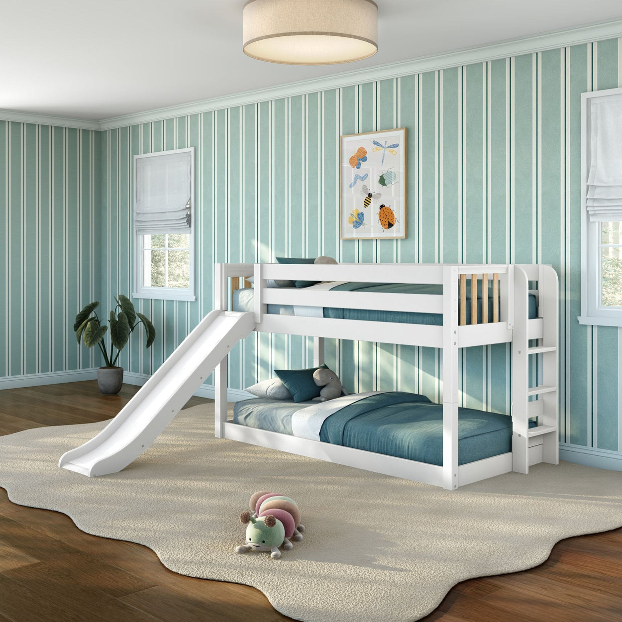 White wooden bunk bed with slide and ladder in modern children's bedroom with teal-striped wallpaper, blue bedding, cream area rug and plush caterpillar toy