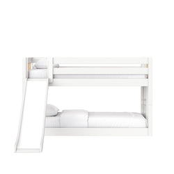 White wooden twin-over-full bunk bed with slide, safety rails and ladder, styled with white bedding in a minimalist kids' bedroom