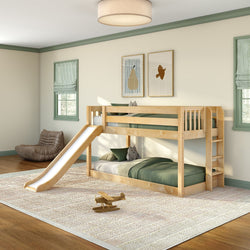 Wooden kids bunk bed with slide and ladder in bright children's bedroom with green bedding, toy airplane and plush pillows