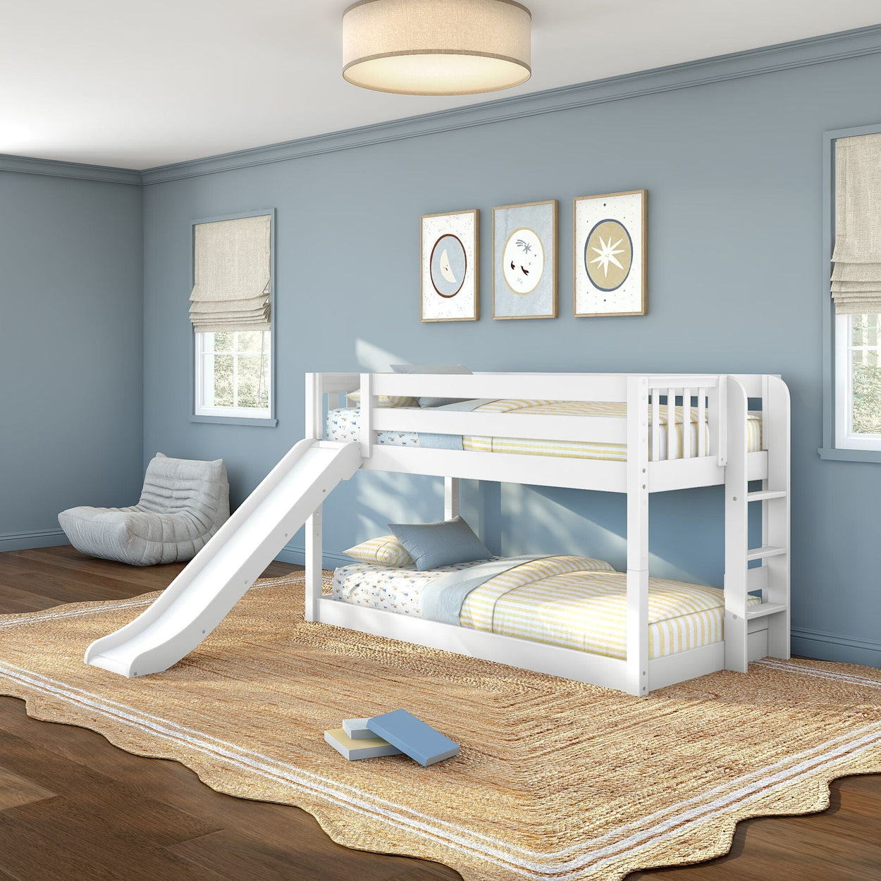 White wooden twin-over-twin bunk bed with slide in children's bedroom, blue walls, striped bedding, jute rug, hardwood floor, moon and star wall art