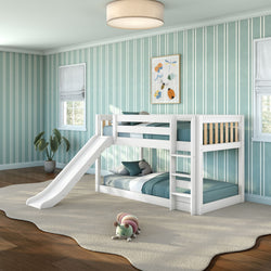 White wooden bunk bed with slide and ladder in modern kids' bedroom with teal striped wallpaper, hardwood floors, beige area rug, and plush caterpillar toy
