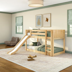 Children's bedroom with natural pine bunk bed featuring a slide and ladder, green bedding, plush toys and wooden airplane on an area rug in a light-filled modern room