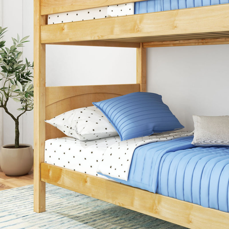 Light wood bunk bed with blue quilted bedding and star-patterned white sheets in a modern kids' bedroom with a potted plant
