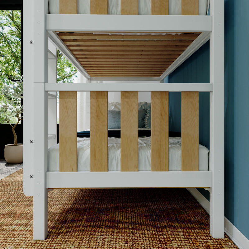 White wooden bunk bed with natural wood slats in a modern kids' bedroom with blue accent wall, woven rug, potted plant and cozy bedding