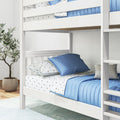 White wooden bunk bed with blue quilt and star print sheets, ladder and potted plant in modern kids' bedroom