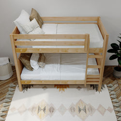 Wooden bunk bed with cozy pillows and neutral bedding in a modern bedroom setting.