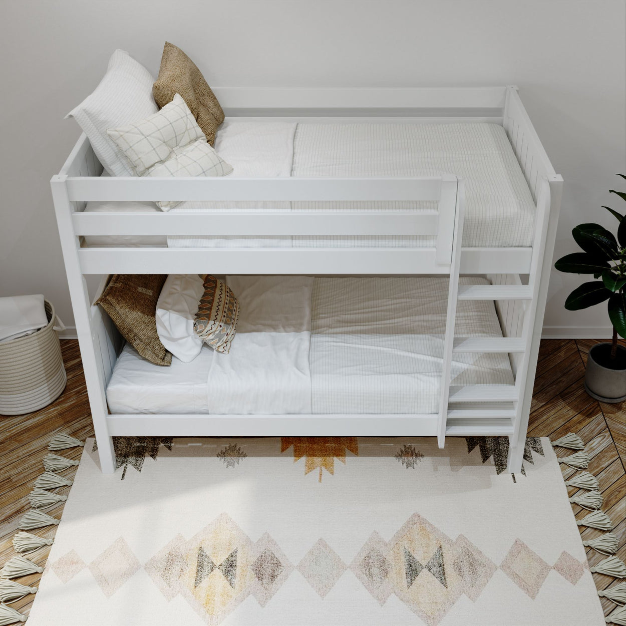White wooden bunk bed with cozy pillows in a modern bedroom setting featuring a decorative rug and indoor plant.