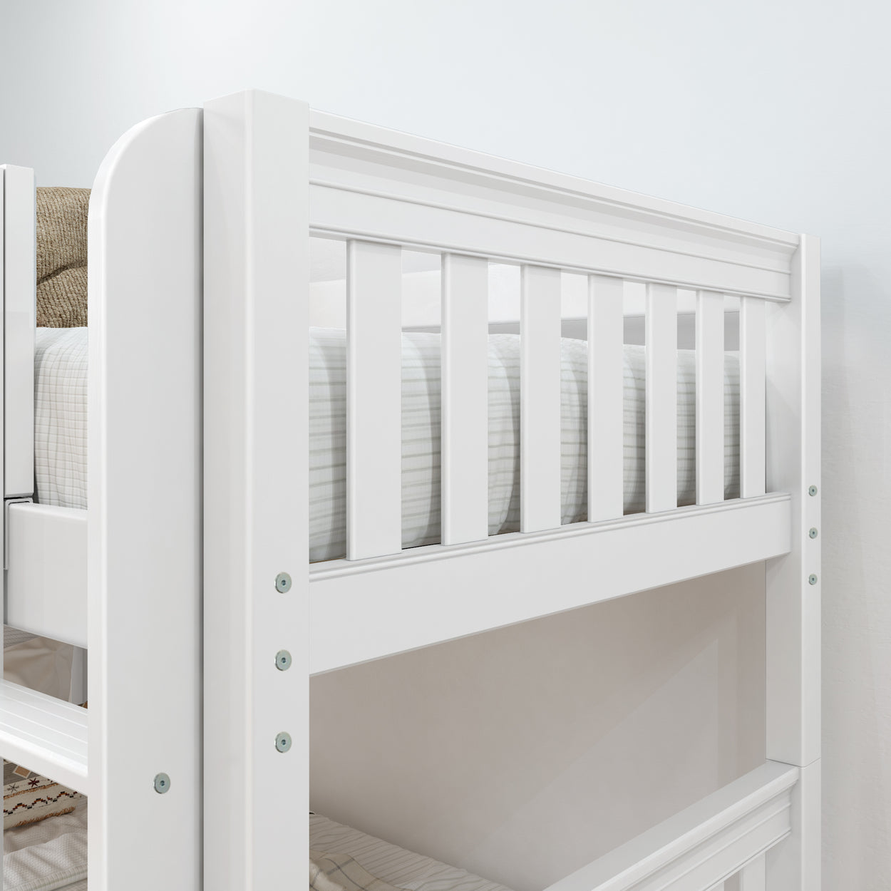 White wooden bunk bed with slatted design and striped bedding in a modern bedroom setting.