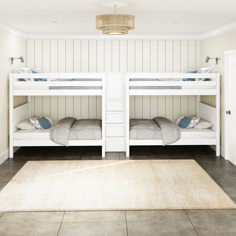 White wooden twin-over-twin bunk beds in a coastal farmhouse kids bedroom with shiplap paneled walls, center storage ladder with drawers, neutral gray bedding, blue accent pillows, wall-mounted reading lamps, rattan pendant light and beige area rug