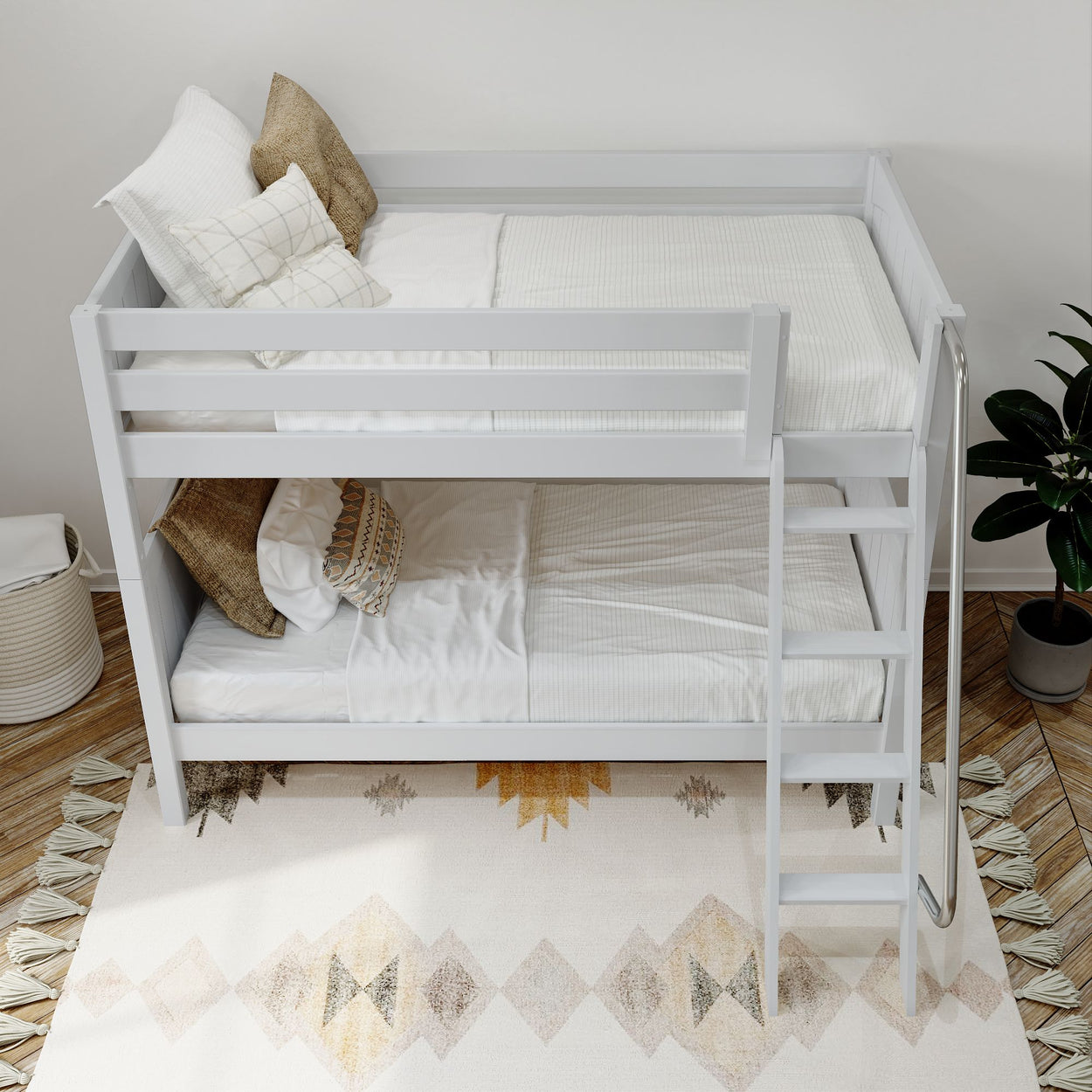 White wooden bunk bed with cozy pillows in a stylishly decorated bedroom featuring geometric patterns and a potted plant.