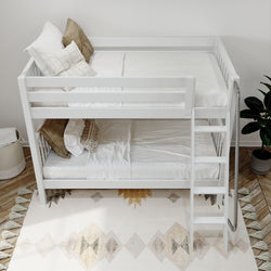 Modern white bunk bed with cozy pillows, ladder, and stylish decor in a bright bedroom setting.