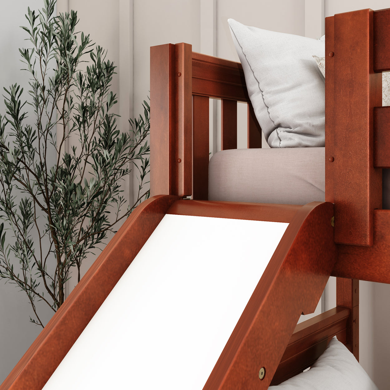 Wooden loft bed with slide and cozy cushions in a child-friendly room featuring decorative plants.
