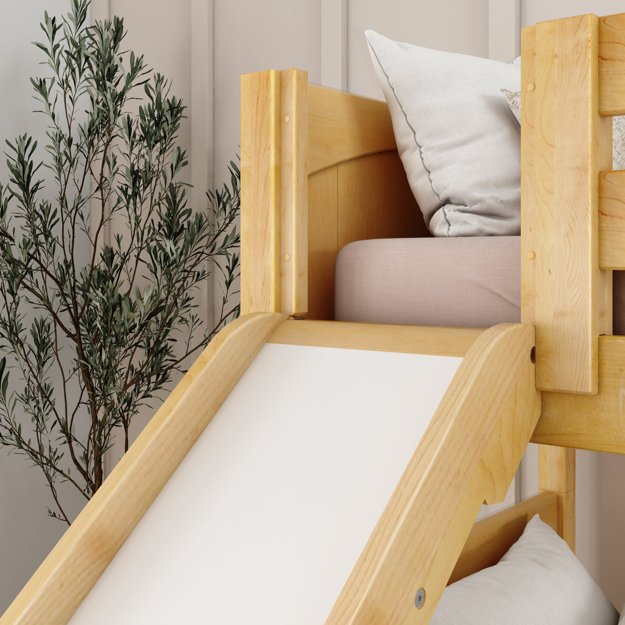 Kids' room with wooden slide bed and cozy pillows near a decorative plant.