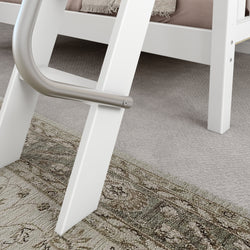 White bed ladder with safety handle on a patterned rug and carpet floor.