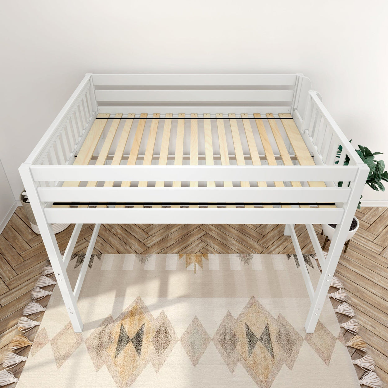 White wooden twin loft bed frame with slatted wood mattress support and safety rails, space-saving raised platform over beige geometric rug on herringbone wood floor