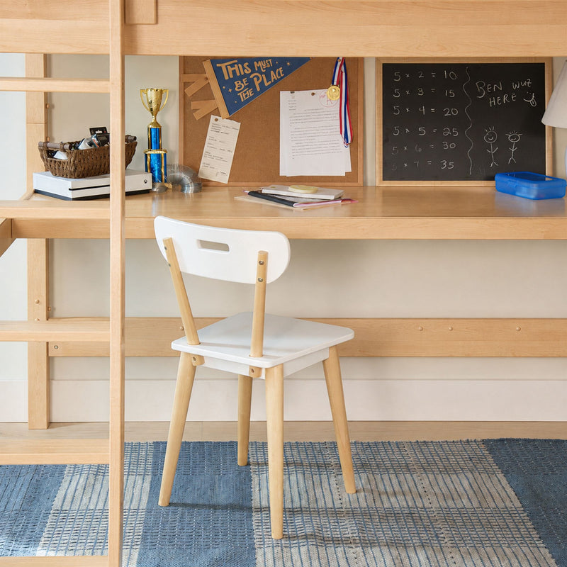 Kids study nook under loft bed — light wood desk with white chair, corkboard pennant, trophy and medal, chalkboard math and school supplies