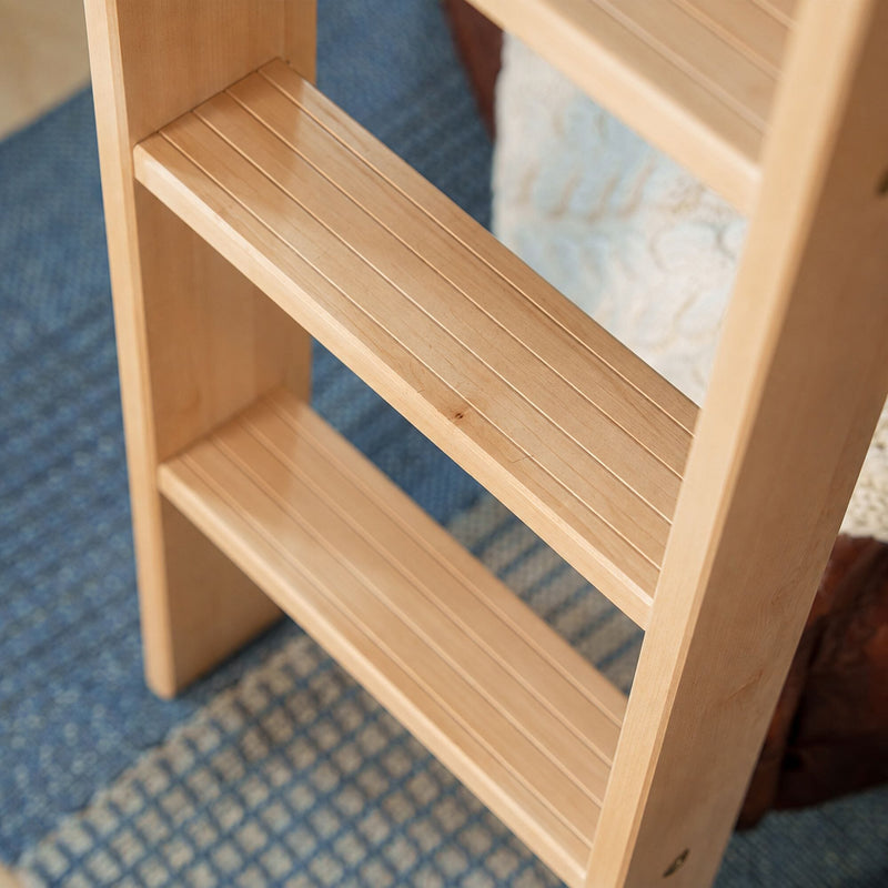 Light maple wooden leaning ladder shelf with grooved slatted shelves on blue patterned rug, modern home storage ladder