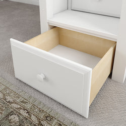 White wooden open drawer on carpeted floor with a close-up view.