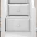 Close-up of white modern dresser drawers with round knobs in built-in shelving, minimalist bedroom storage solution