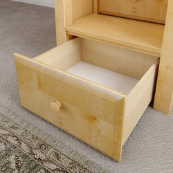Open wooden drawer on carpet floor in a home interior setting.