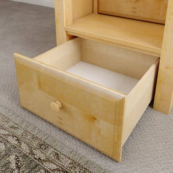 Open wooden drawer in a light-colored cabinet on carpeted floor.