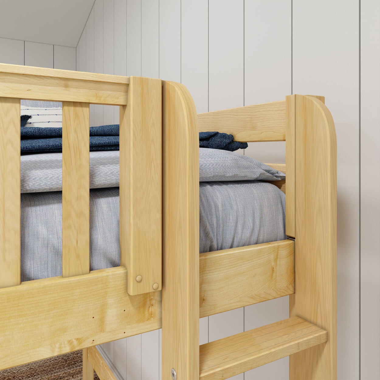 Close-up of a light wooden bunk bed showing top bunk guardrail, ladder step, gray bedding and natural wood grain against a white paneled wall