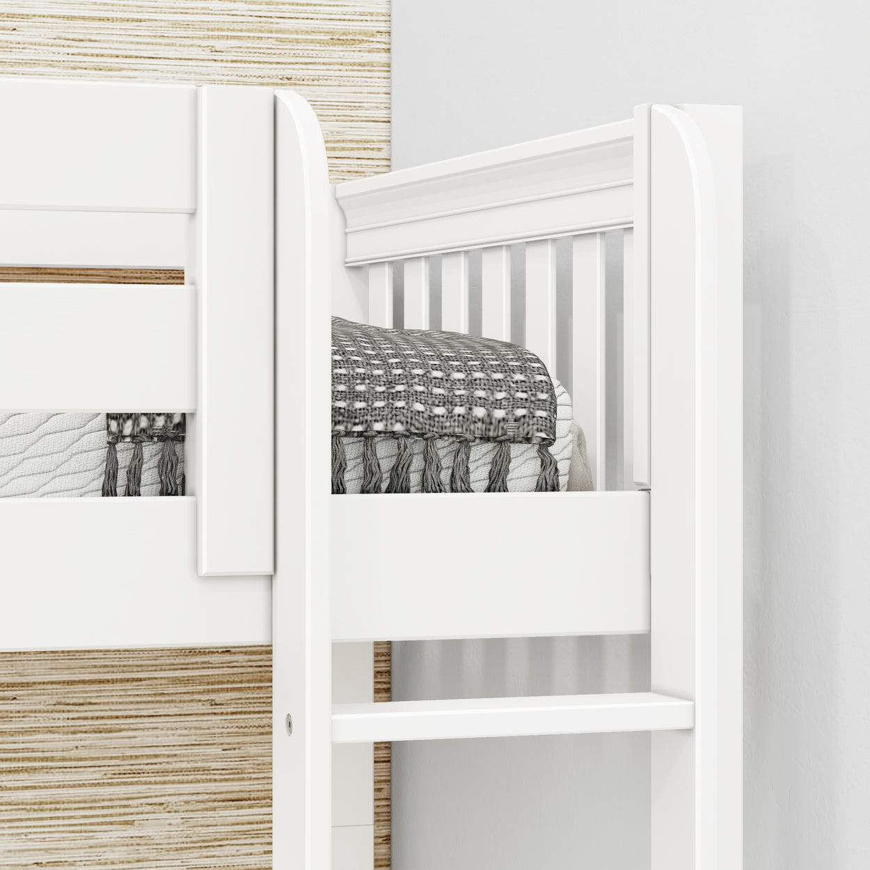 White wooden bunk bed rail with gray and white patterned bedding in a child’s bedroom.