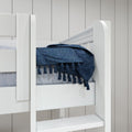Close-up of a white wooden bunk bed with navy blue tasseled throw and light gray paneled wall in a modern bedroom