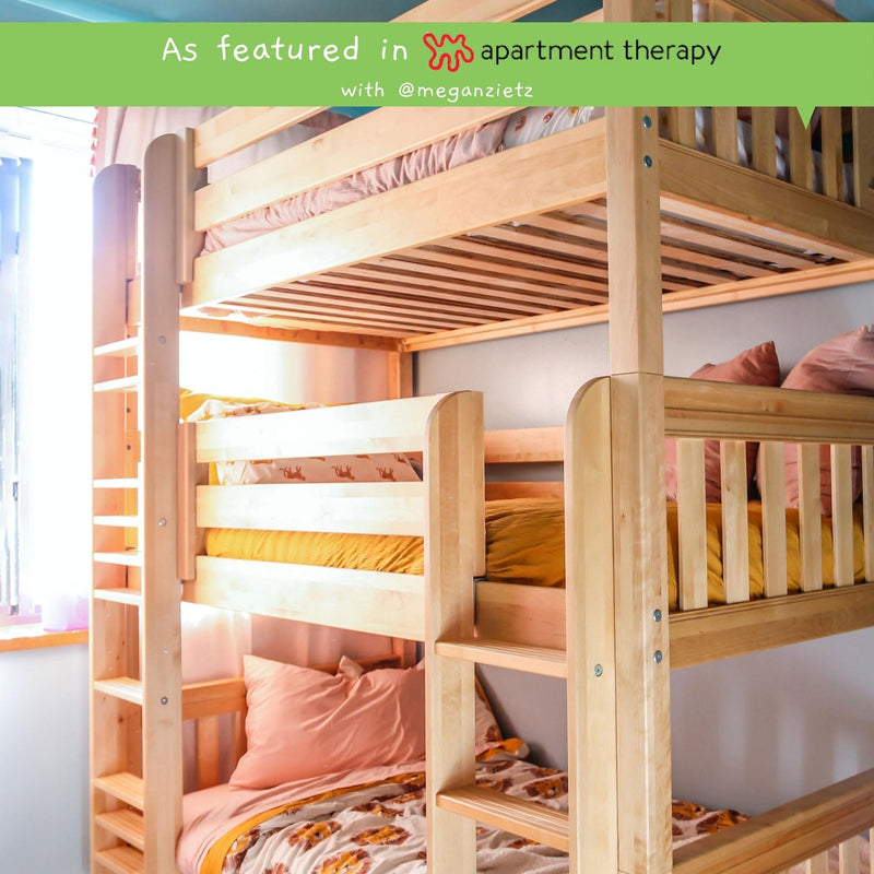 Natural wood bunk beds with ladder in a bright kids' bedroom, pink and mustard bedding, space-saving loft-style design