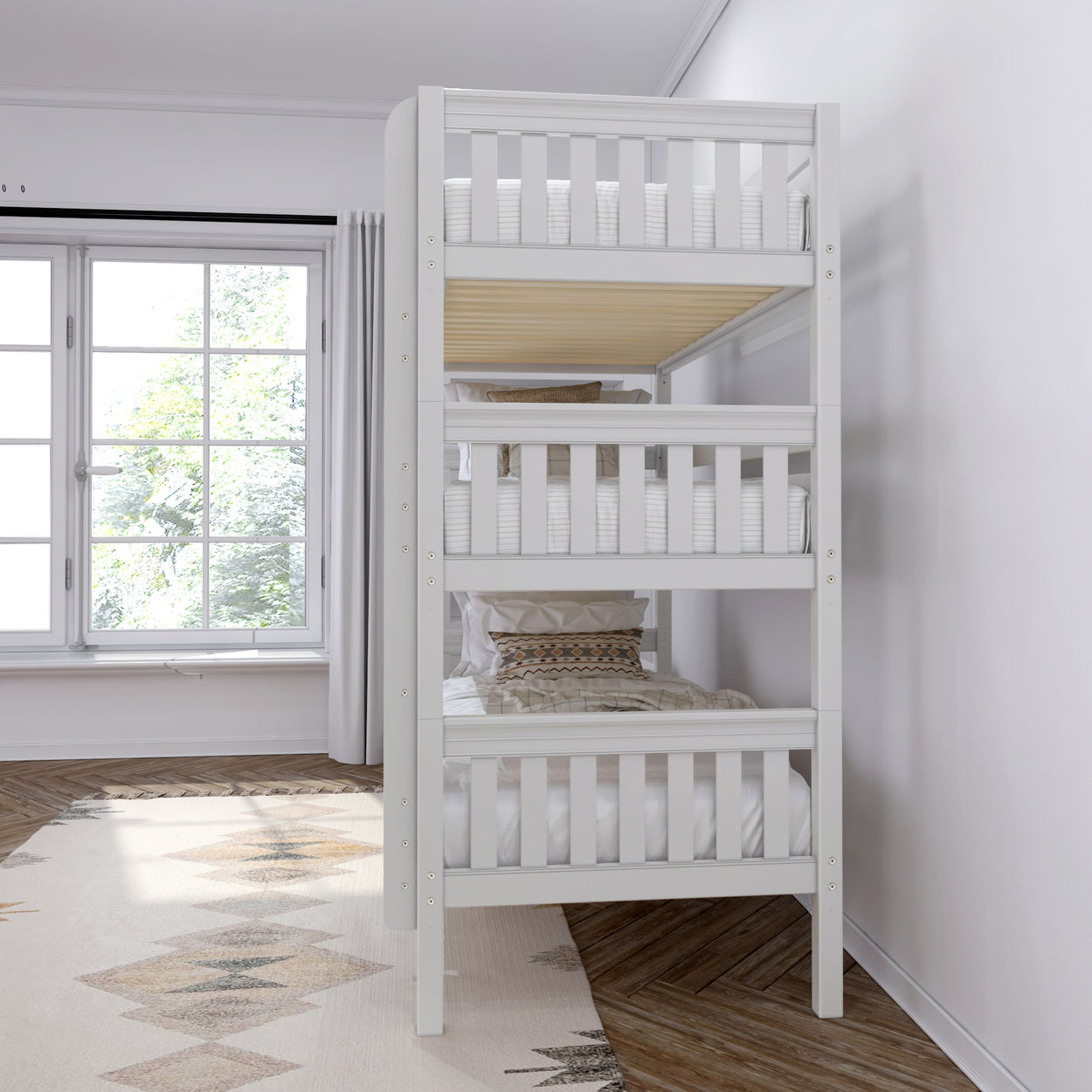 White wooden triple bunk bed in modern bedroom with large window and patterned rug.