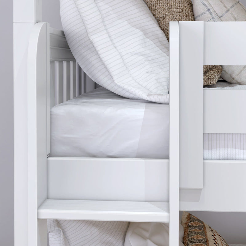 White wooden bunk bed close-up with ladder, white striped duvet and neutral decorative pillows in modern nursery
