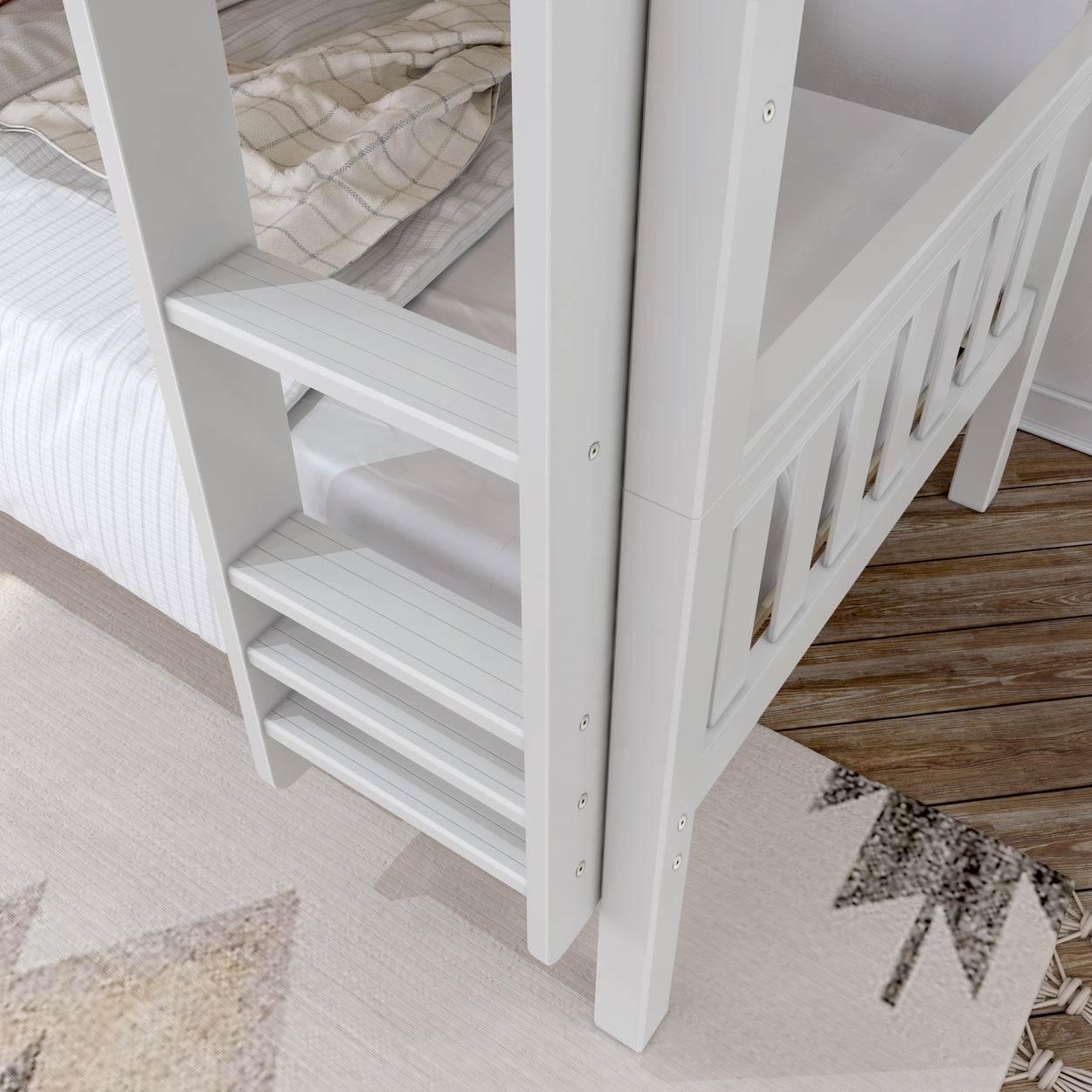 White wooden bunk bed ladder next to striped bedding and patterned rug on hardwood floor.