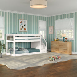 Children's bedroom with white twin-over-twin bunk bed with stairs, teal vertical striped wallpaper, light wood dresser, soft area rug and plush caterpillar toy