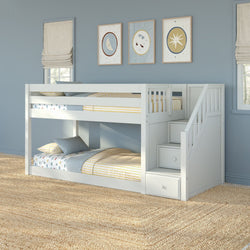 White twin-over-twin bunk bed with built-in storage stairs and drawers in a blue kids' bedroom with yellow-striped bedding and jute rug