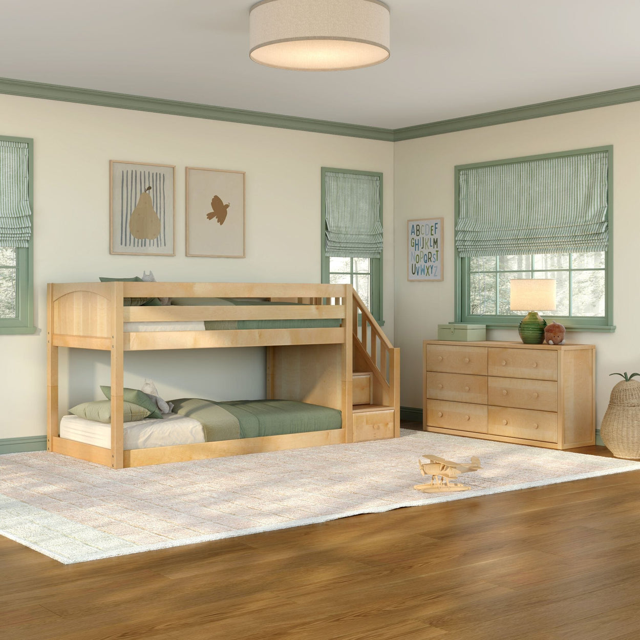 Natural wood twin-over-twin bunk bed with built-in staircase and green bedding in a kids' bedroom with coordinating six-drawer dresser, hardwood floors, area rug, and framed wall art