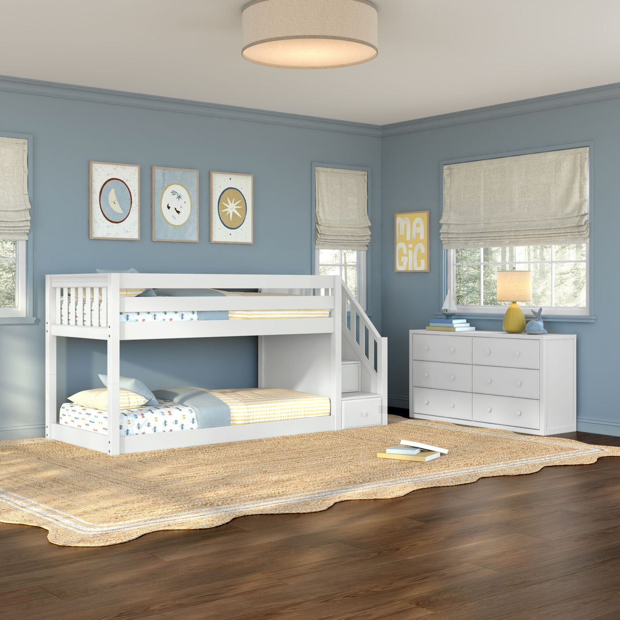 Kids room with white twin-over-twin bunk bed with stairs, blue painted walls, woven jute rug, white dresser, lamp and wall art