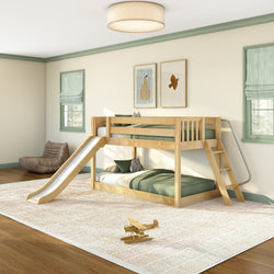 Kids wooden bunk bed with slide and ladder in light green-accented bedroom, twin mattresses, cozy rug and wooden toy airplane