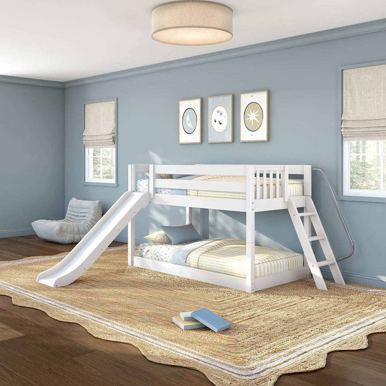 White children's bunk bed with slide and ladder in a light-blue kids' bedroom, twin-over-twin striped bedding, jute rug and framed wall art