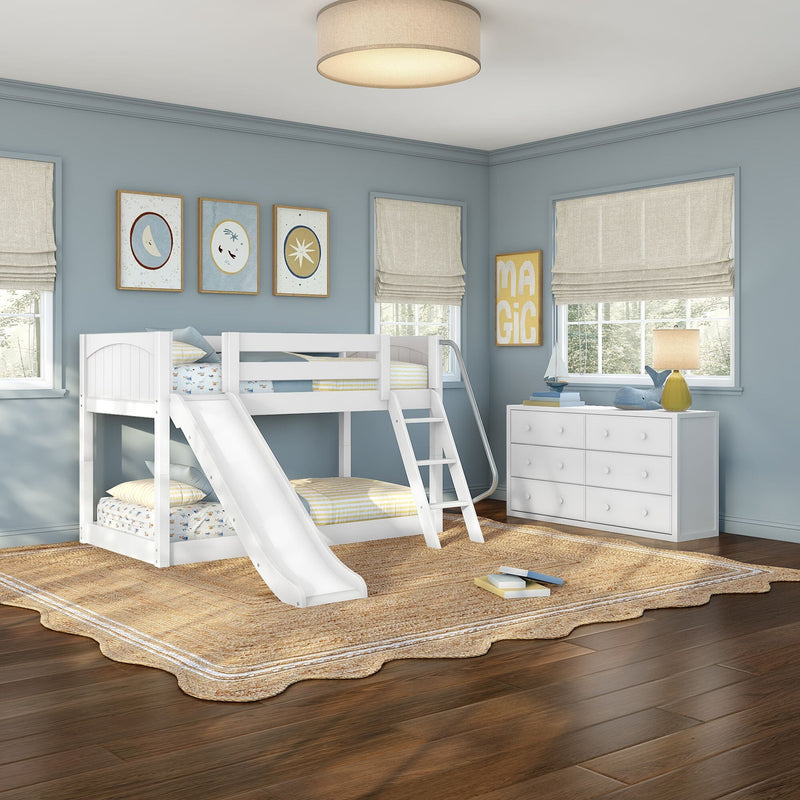 Kids bedroom with white bunk bed and slide, soft blue walls, beige Roman shades, natural jute rug, white dresser, hardwood floor and nautical decor