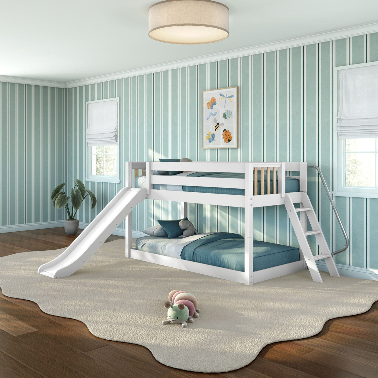 White wooden twin-over-twin bunk bed with slide and ladder in children's teal-striped bedroom, teal bedding, potted plant and plush caterpillar on cream rug