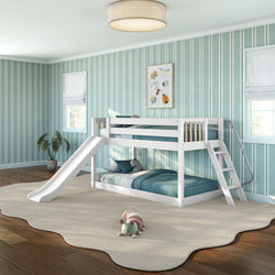 White wooden twin-over-twin bunk bed with slide and ladder in children's teal-striped bedroom, teal bedding, potted plant and plush caterpillar on cream rug