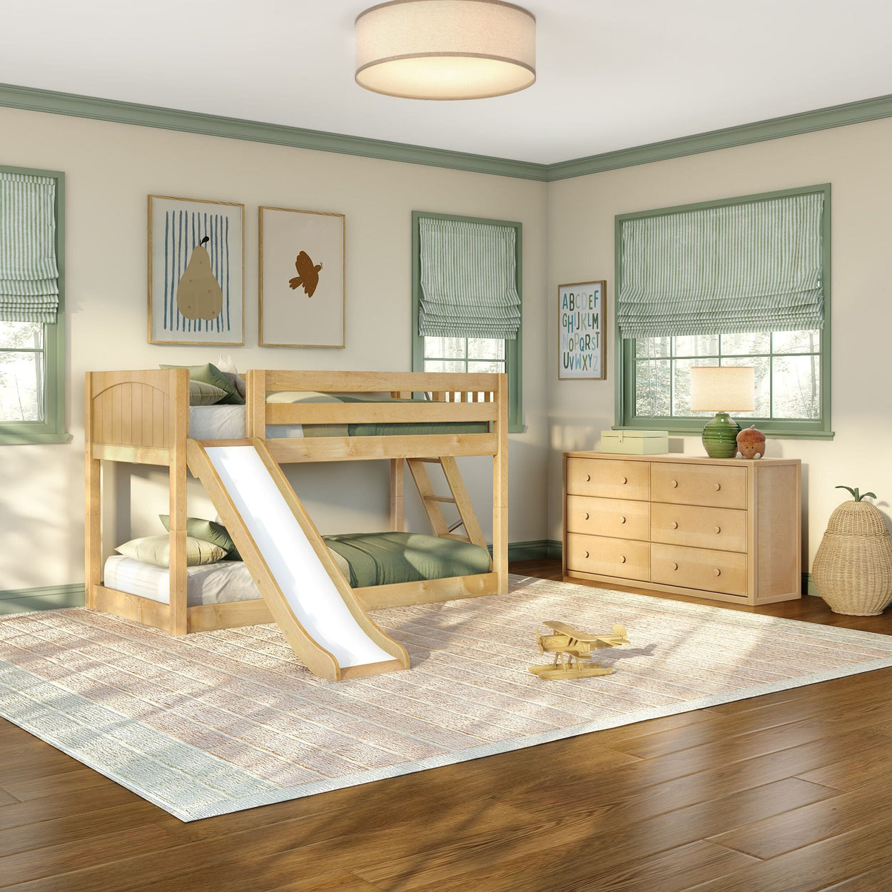 Sunlit children's bedroom with natural wood twin-over-twin bunk bed with slide, green-striped roman shades, matching wooden dresser, area rug and wooden toy airplane, modern kids' room design
