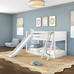 White wooden twin-over-twin bunk bed with slide and ladder in a modern blue kids' bedroom with striped bedding, natural jute rug, cozy lounge chair, and framed wall art.